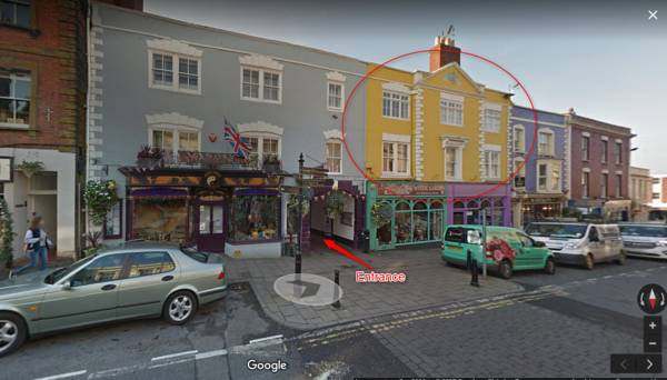 Street view of the yellow 8 Owls building on the High Street